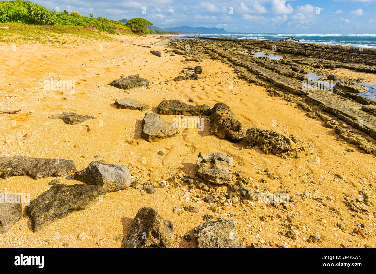 Exponiertes Korallenriff mit schlafendem Riesenberg in der Ferne, Nukolii Beach, Kauai, Hawaii, USA Stockfoto