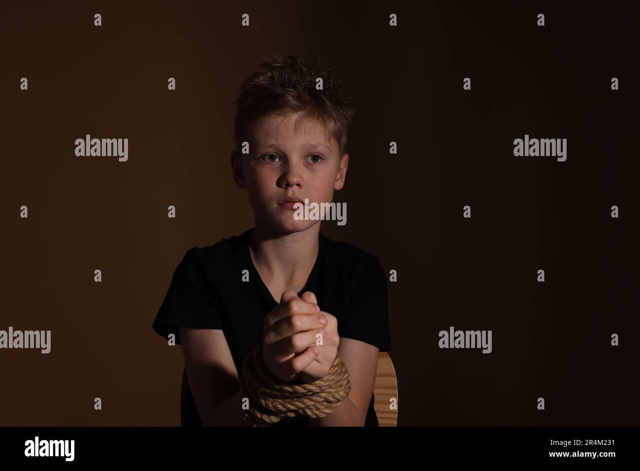 Ein kleiner Junge gefesselt und auf dunklem Hintergrund als Geisel genommen  Stockfotografie - Alamy