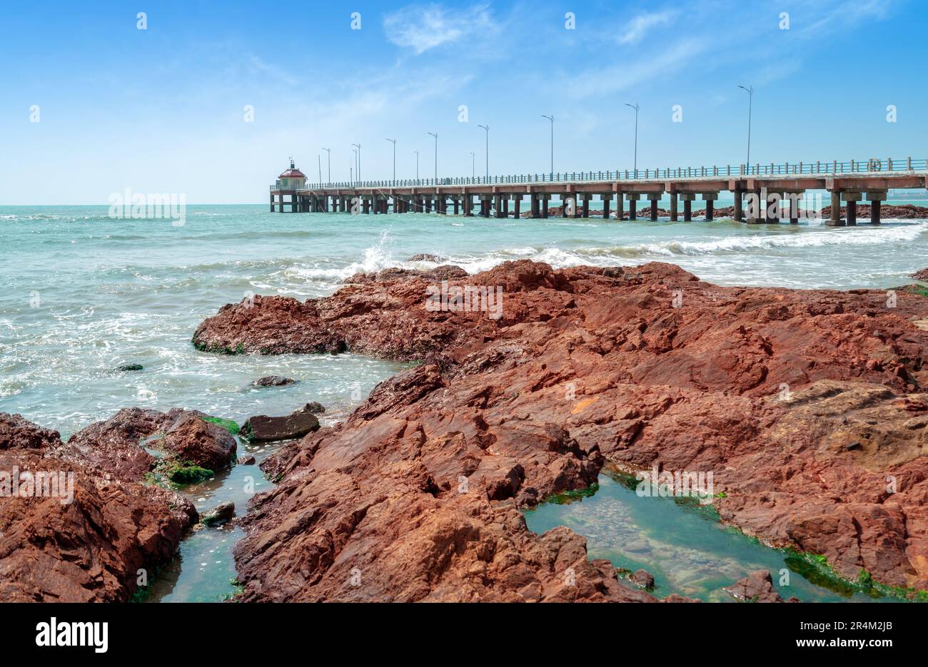 Die Baumbrücke und die roten Riffe am Meer, die natürliche Landschaft von Hainan, China. Stockfoto