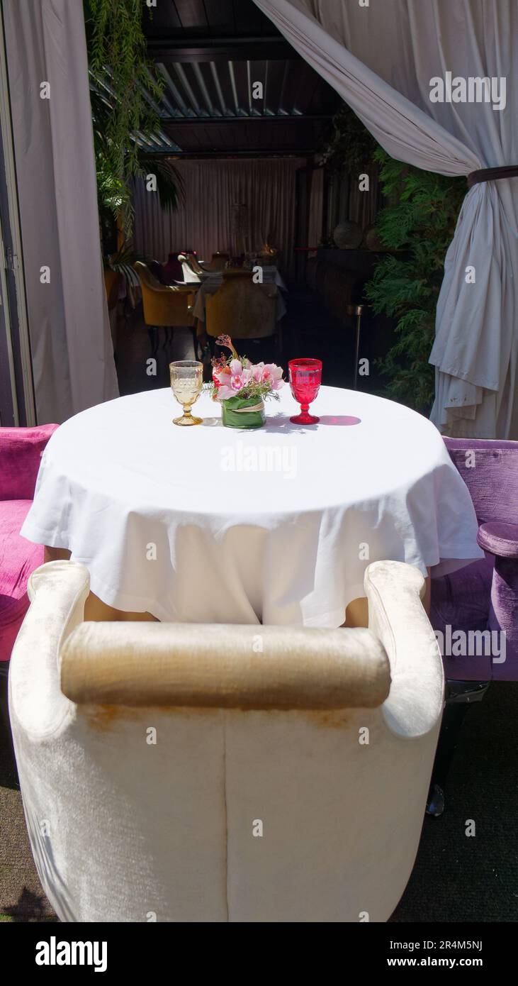 Einfache, aber elegante Restauranttische im Freien in Mailand mit zwei Gläsern und Blumen. Lombardei, Italien Stockfoto