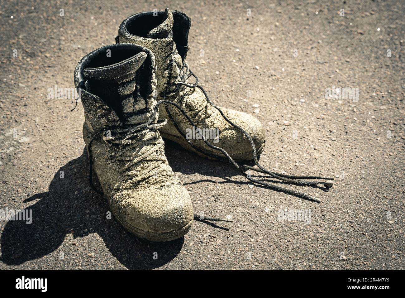 Dreckige, alte Arbeitsstiefel. Schuhe mit Polyurethanschaum verschmutzt Stockfoto