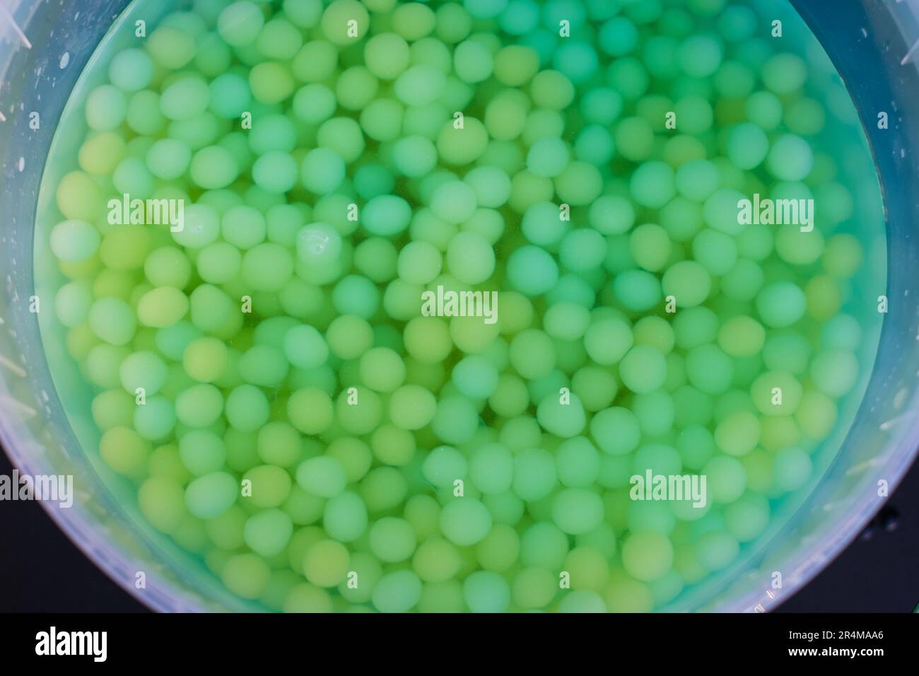 Großer Eimer voller grüner boba-Bälle in Flüssigkeit. Stockfoto