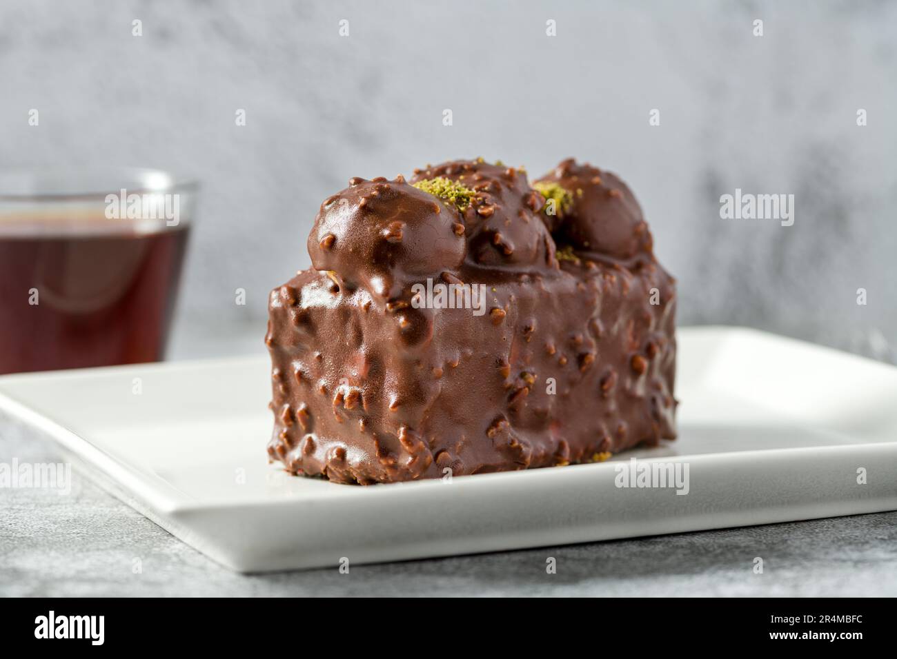 Kuchen mit Profiteroles und Tee auf einem Steintisch Stockfoto