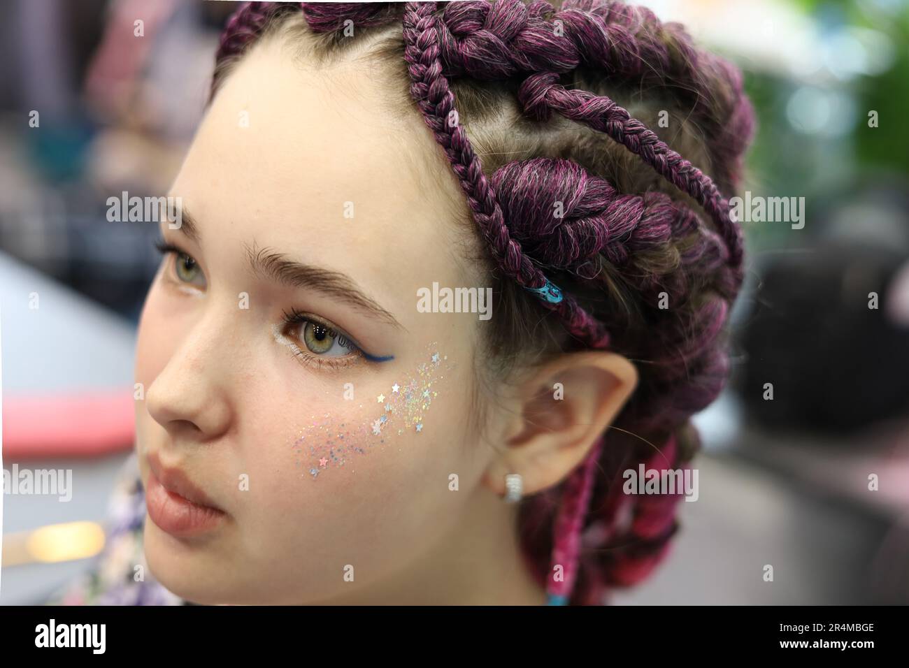 Mädchen mit braunen Haaren und Zöpfen, geflochten mit künstlichem Haargeflecht. Stockfoto