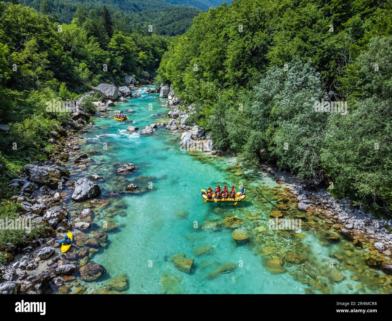 Soca-Tal, Slowenien - Luftaufnahme des smaragdgrünen alpinen Flusses Soca mit Rafting-Booten auf dem Fluss an einem hellen, sonnigen Sommertag Stockfoto