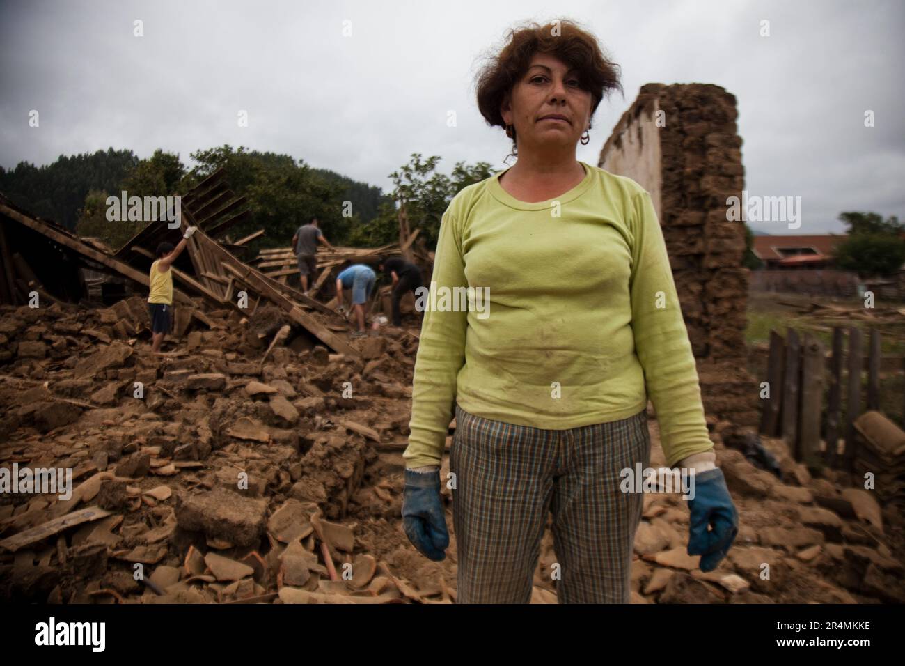 Porträt einer einheimischen Frau vor den Trümmern eines eingestürzten Gebäudes, das bei dem Erdbeben in Chile Anfang 2010 zerstört wurde. Stockfoto