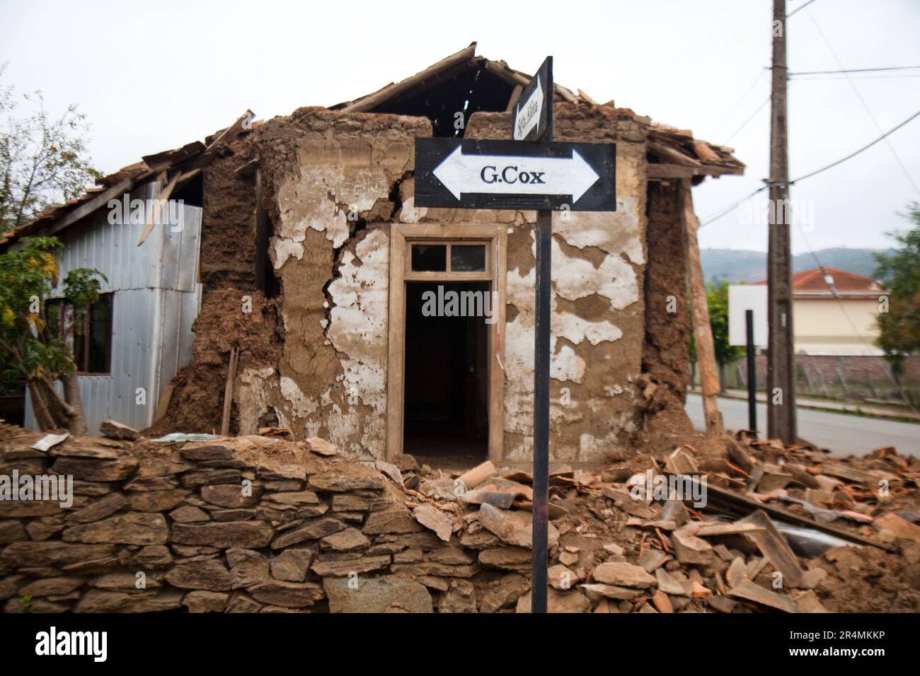 Ein Straßenschild vor einem schwer beschädigten Haus nach dem verheerenden Erdbeben, das Chile Anfang 2010 heimsuchte. Stockfoto