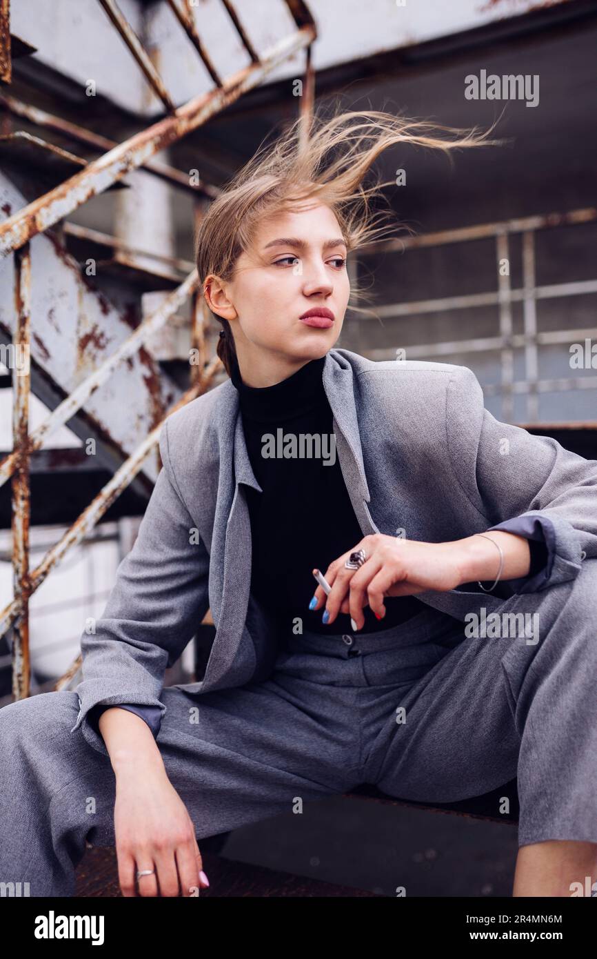 Eine Frau, die vom Wind wegschaut, bläst ihr die Haare Stockfoto