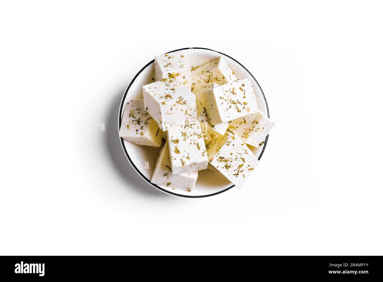 Griechischer Feta-Käse isoliert auf weißem Hintergrund, Draufsicht. Frische Fetakäse mit Kräutern. Stockfoto