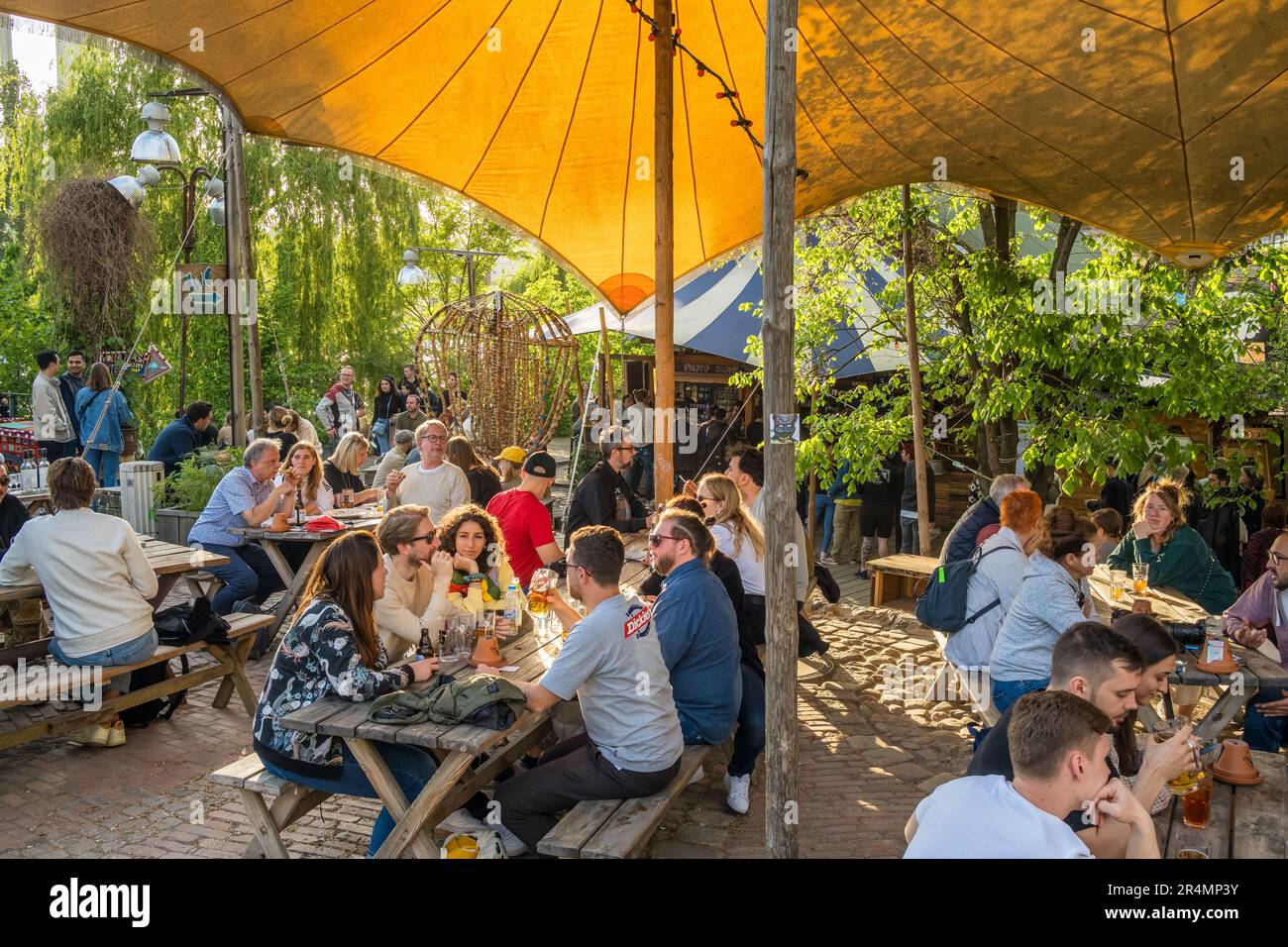 Unbekannte Menschen hängen im Sommer in Berlin in einer gemütlichen Café-Bar im Freien am Ufer der Spree ab Stockfoto