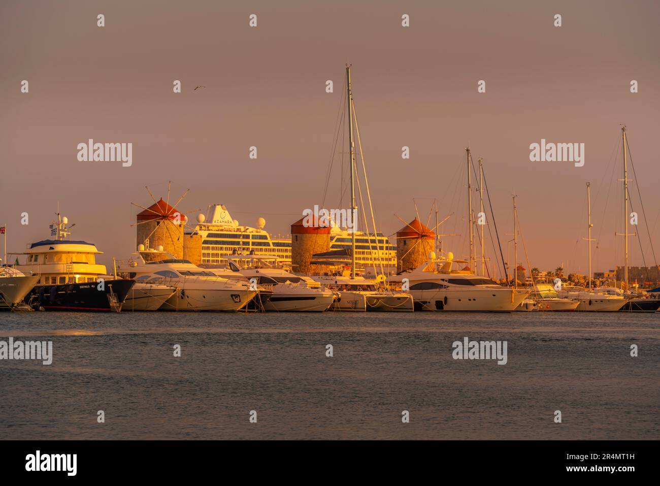Blick auf Rhodos Windmühlen im Hafen von Mandraki bei Sonnenuntergang, Altstadt der Stadt Rhodos, Rhodos, Dodekanesische Inseln, griechische Inseln, Griechenland, Europa Stockfoto