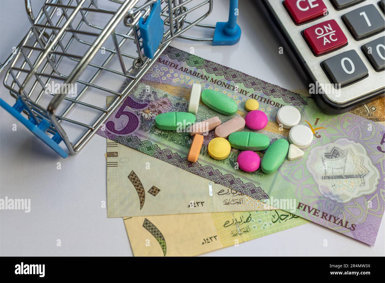 Pillen und Tabletten im Mini-Einkaufswagen mit KSA-Banknoten Stockfoto