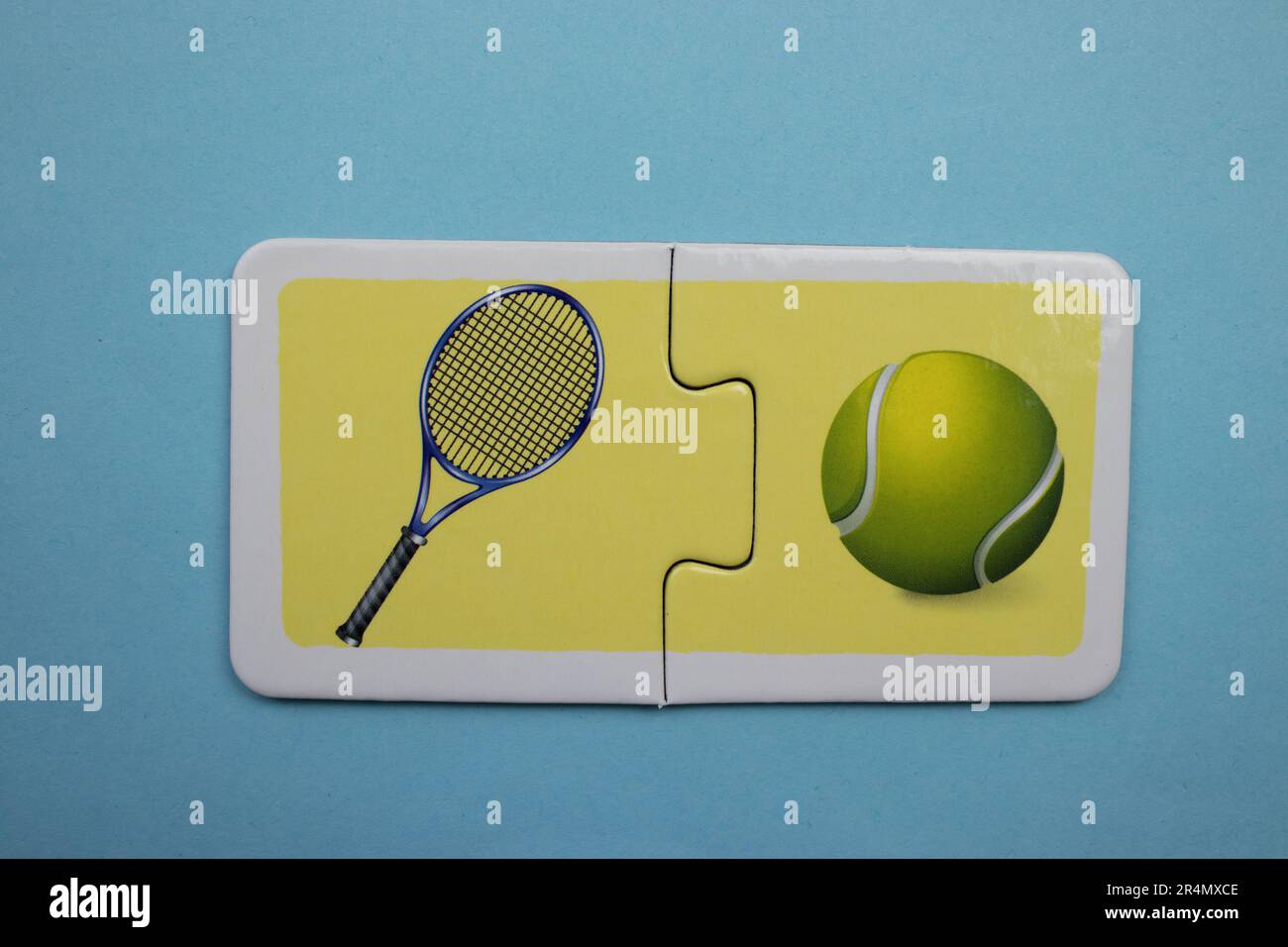 Puzzles auf blauem Hintergrund überlagern. Tennisschläger und Ball von oben fotografiert. Stockfoto