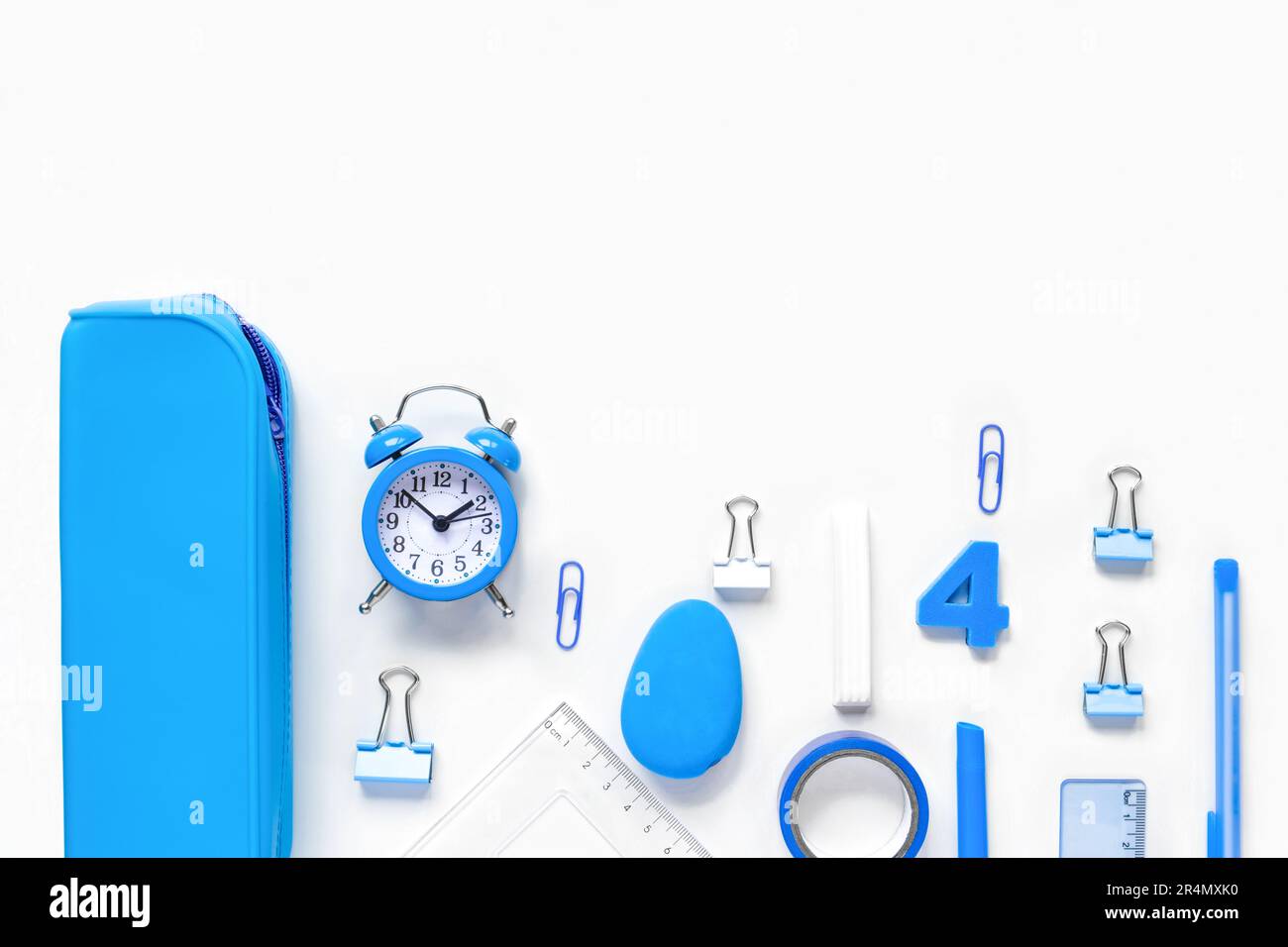 Schulanfang, Berufsbildungskonzept. Sortiment an blauen Vorräten, Buntstiften, Uhr, Stiften auf einem Tisch. Hintergrund des Kopierbereichs, Draufsicht flach Stockfoto