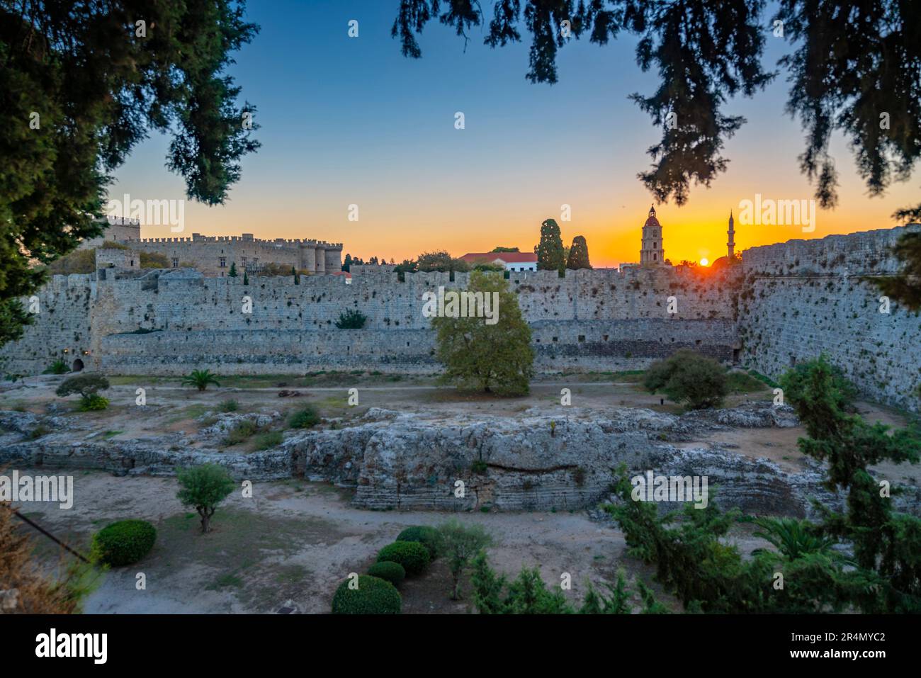 Blick auf den Sonnenaufgang zwischen dem mittelalterlichen Uhrturm und der Suleiman-Moschee, Rhodos-Stadt, Rhodos, Dodekanesische Inselgruppe, griechische Inseln, Griechenland, Europa Stockfoto