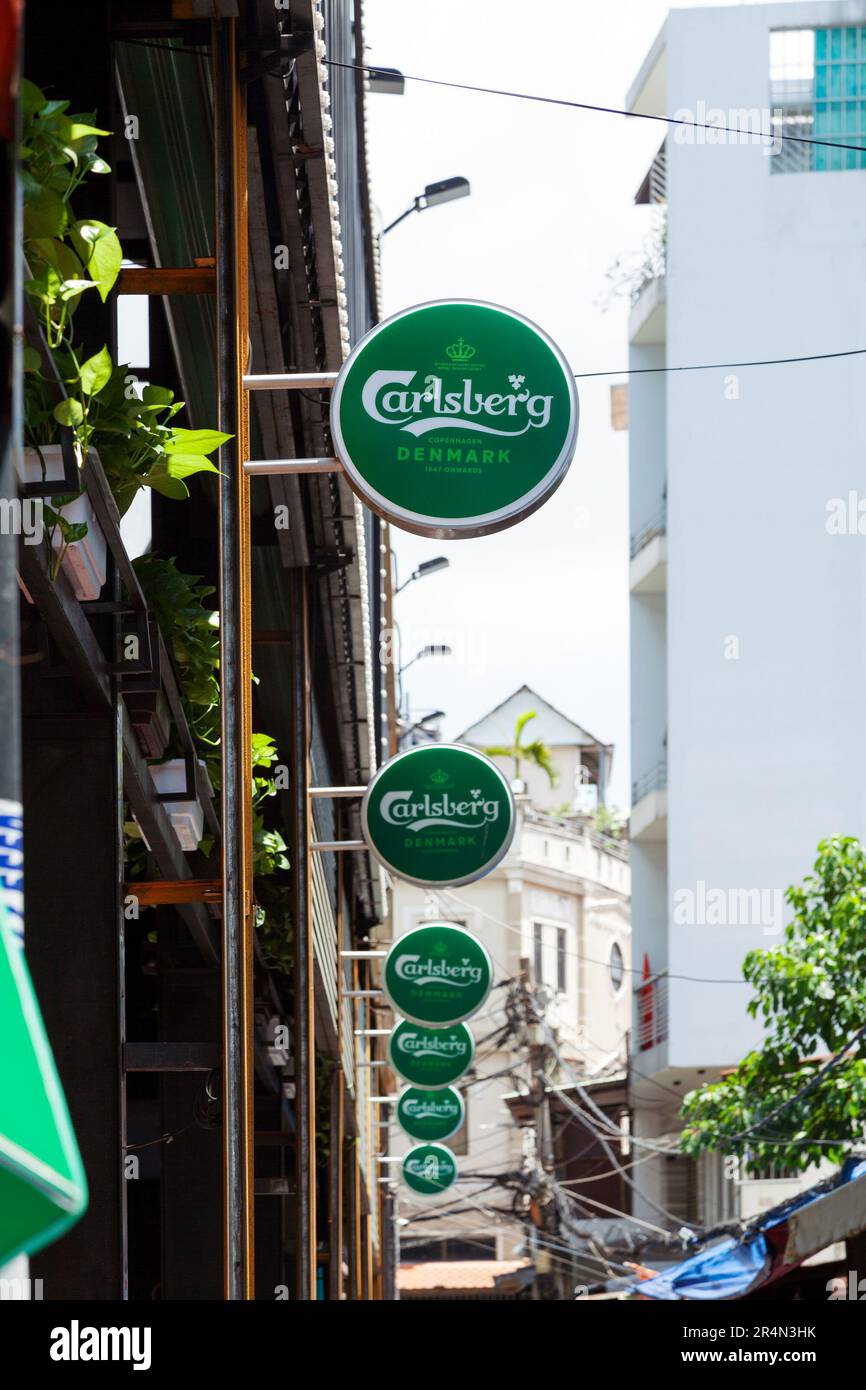 Ho-Chi-Minh-Stadt, Vietnam - 22. Mai 2023: Runde grüne Handelsschilder mit Carlsberg-Bier-Logo vor einer Bar. Beliebte Werbung für alkoholische Getränke Stockfoto