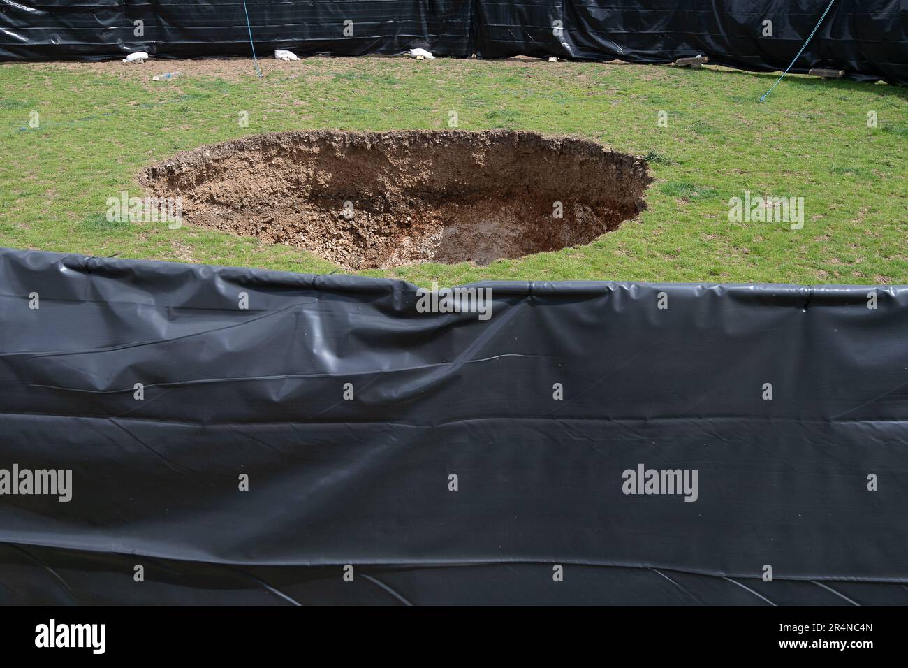 Amersham, Buckinghamshire, Großbritannien. 29. Mai 2023. Ein großes Sinkloch über den HS2 High Speed Rail Chiltern Tunnels erschien am Samstag, den 13. Mai im Bazzards Field neben Shardeloes Lake, Amersham, Buckinghamshire. Das Sinkloch wurde von HS2 eingezäunt. HS2 Arbeiter saßen heute in Lieferwagen auf den nächsten beiden Feldern des Sinklochs und überwachten sie. Heute waren auch Fachfirmen für die Strukturüberwachung in Socotec an diesem Standort tätig. Die Einheimischen und Wanderer sind nach wie vor sehr besorgt über das Sinkhole und ob weitere Sinklöcher entstehen werden. Kredit: Maureen McLean/Alamy Live News Stockfoto