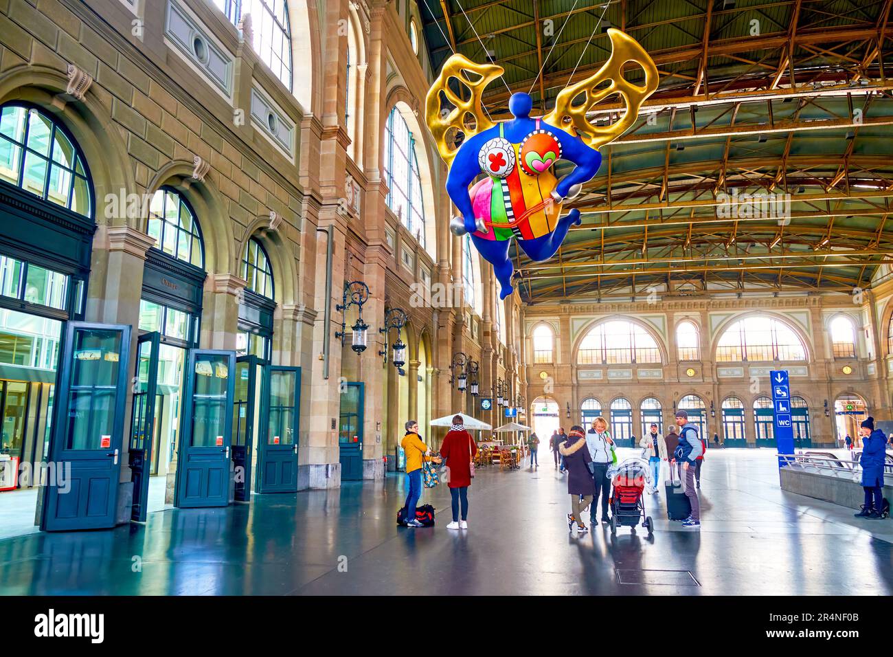 ZÜRICH, SCHWEIZ - 3. APRIL 2022: Haupthalle des Züricher Hauptbahnhofs mit farbenfroher L'ange-Protekteur-Skulptur von Niki de Saint Phalle am April Stockfoto