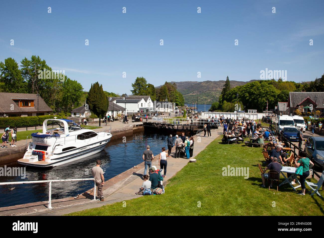 Fort Augustus, Highland, Schottland, Großbritannien, 29. Mai 2023. Geschäftiger Feiertag am Montag an den Schleusen des Caledonian Canal mit Hunderten von Touristen, die herumschleichen und die Schiffe durch die Schleusen beobachten. Temperatur 16 Grad Celsius am Nachmittag. Abbildung: Kintail 1V führt durch die Schleusen im Kanal und schließlich die Drehbrücke. Stockfoto