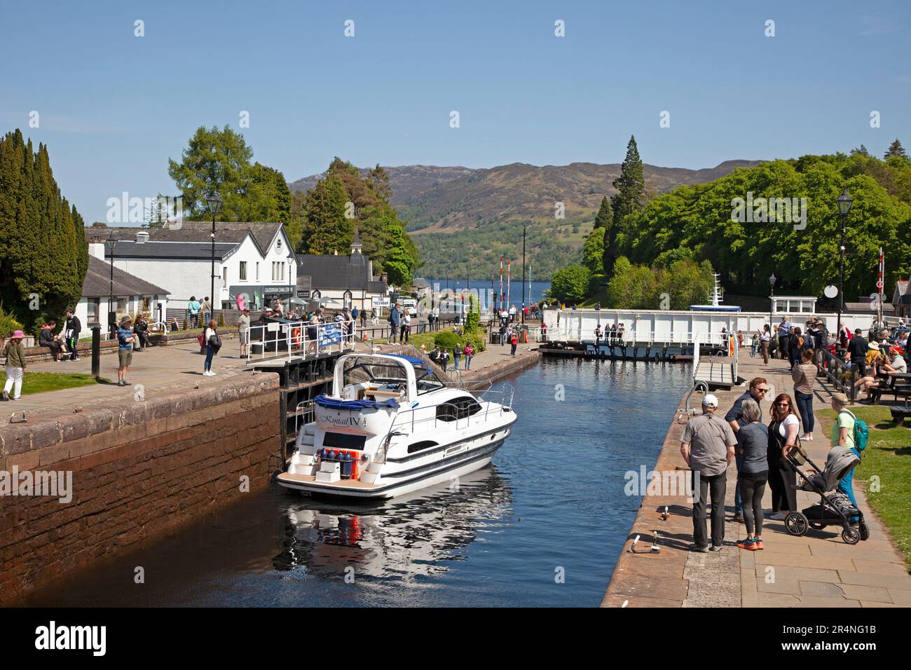 Fort Augustus, Highland, Schottland, Großbritannien, 29. Mai 2023. Geschäftiger Feiertag am Montag an den Schleusen des Caledonian Canal mit Hunderten von Touristen, die herumschleichen und die Schiffe durch die Schleusen beobachten. Temperatur 16 Grad Celsius am Nachmittag. Abbildung: Kintail 1V führt durch die Schleusen im Kanal und schließlich die Drehbrücke. Stockfoto