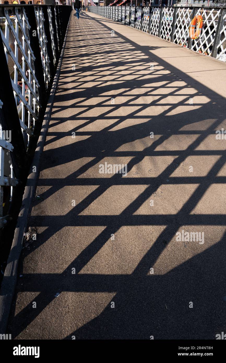 Ein abstraktes Gittermuster an der Balustrade der Fußgängerbrücke auf der South Portland Street Suspension Bridge in Glasgow, Schottland. Stockfoto