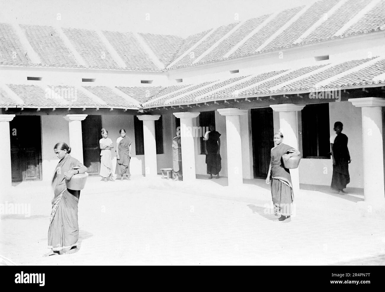 Südindien, von denen Teile heute als Pakistan bekannt sind: Innenhof im Wohnhaus mit Zimmern an den Rändern. Palamathi. Das Mädchen auf der linken Seite wird Wasser in den Messingtopf ziehen, den sie trägt – sie hatte ihre beiden kleinen Kinder zuvor aufgegeben, weil ihr Mann es ablehnte, dass sie Christ sein und bei der Familie bleiben durfte, c1918. Aus einer Serie, die aus dem ursprünglichen Schnappschuss des Ersten Weltkriegs in Indien, c1917-19, aufgenommen wurde. Die Originale waren kleine Fotos, die bei zu großer Vergrößerung schlecht aussehen könnten. Stockfoto