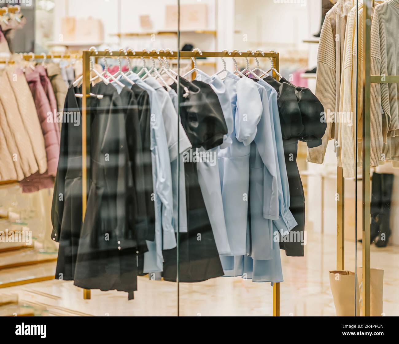 Farbenfrohe Auswahl an legerer Jugendkleidung für Damen. Rack Im Store. Verschwommener Blick durch das Schaufenster. Saisonales Verkaufskonzept Stockfoto