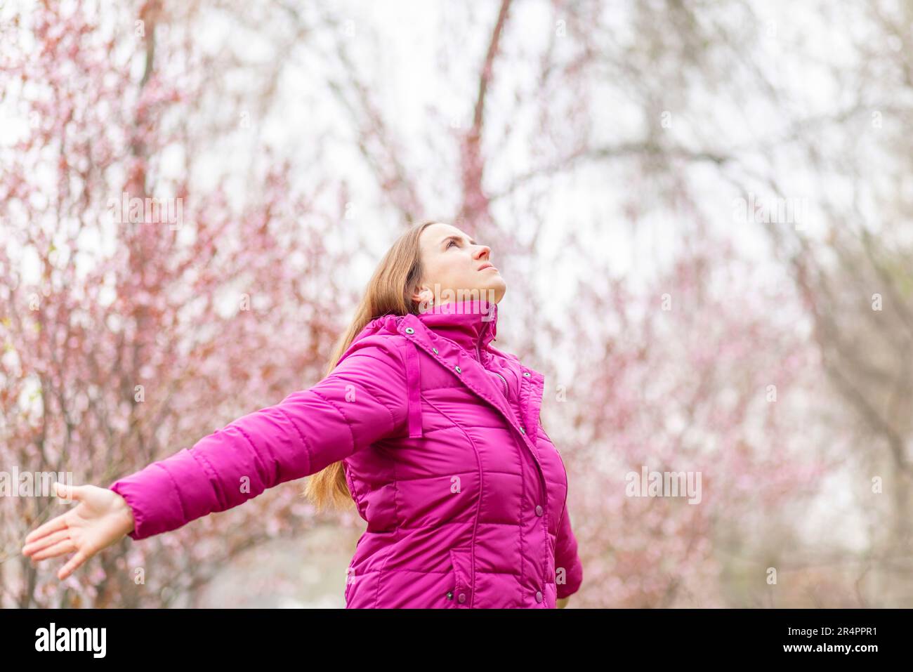 Entspannte Frau mit Kopfhörern, die frische Luft atmet und im Park Musik hört Stockfoto