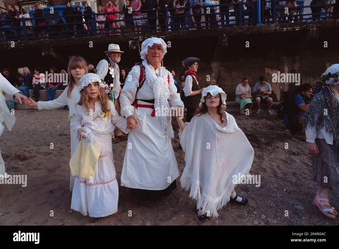 Combe Martin, North Devon, Großbritannien. 29. Mai 2023. Jedes Jahr wiederholen die Menschen aus dem Dorf Combe Martin eine Tradition aus den frühen 1970er Jahren. Ein „Bobby os“ Grenadier und Jungfrauen, die alle die längste Hauptstraße Großbritanniens hinunter zum Strand fahren, bildet Sich Ein riesiger Kreis, und die Grenadier schießen auf den Grafen von Rhone und werfen ihn ins Meer. Kredit: Natasha Quarmby/Alamy Live News Stockfoto