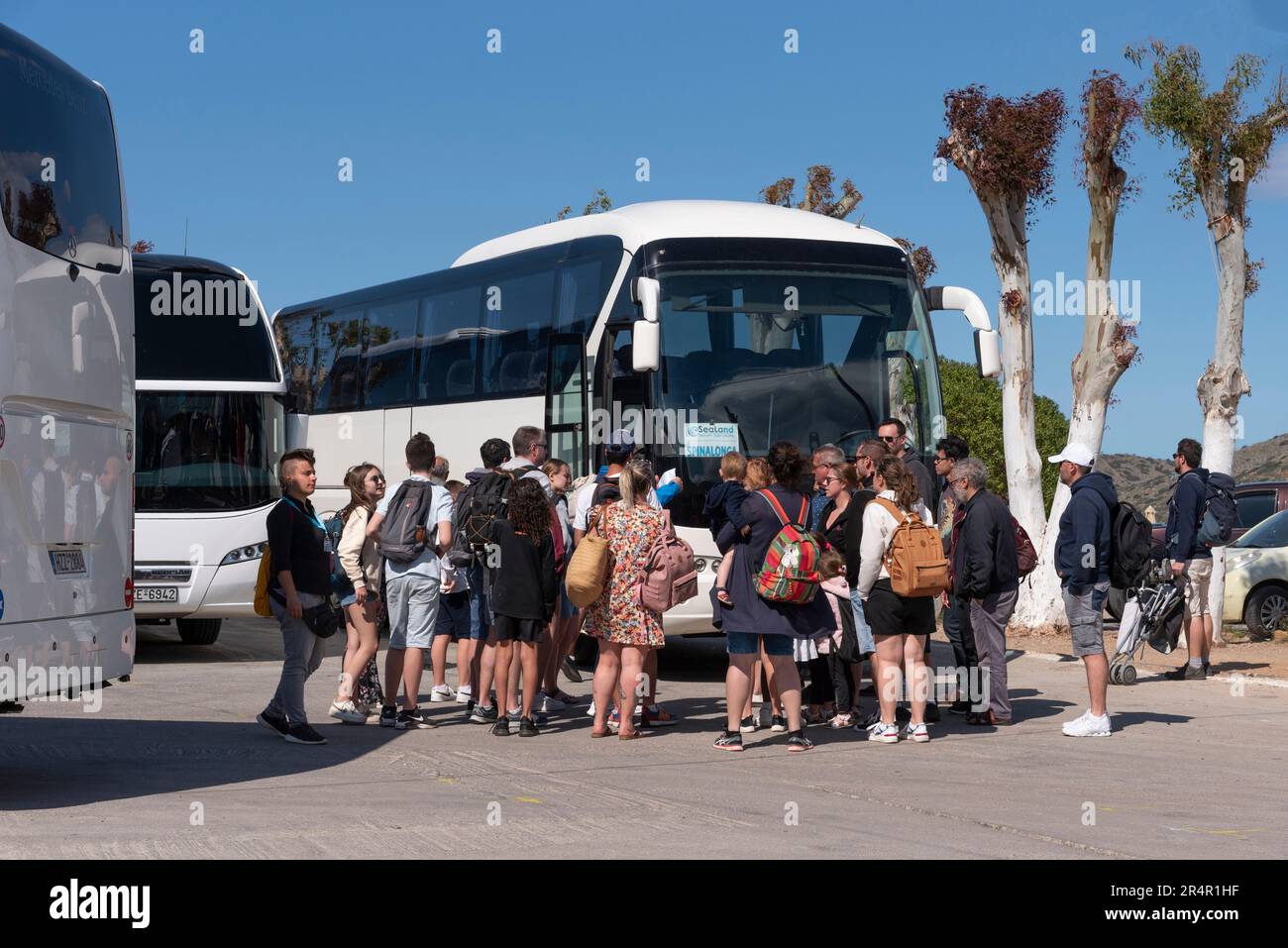 Elounda, Kreta, Griechenland. 2023. Reisende warten am Busbahnhof in Elounda, einem beliebten Küstenresort auf Kreta, auf den Tourbus Stockfoto