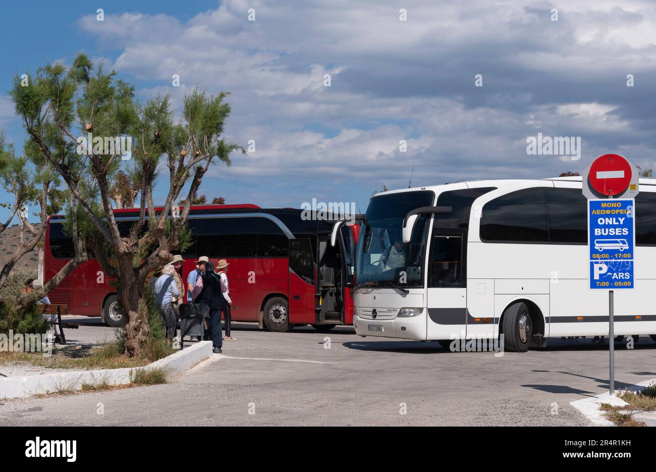 Elounda, Kreta, Griechenland. 2023. Reisende warten am Busbahnhof in Elounda, einem beliebten Küstenresort auf Kreta, auf den Tourbus Stockfoto