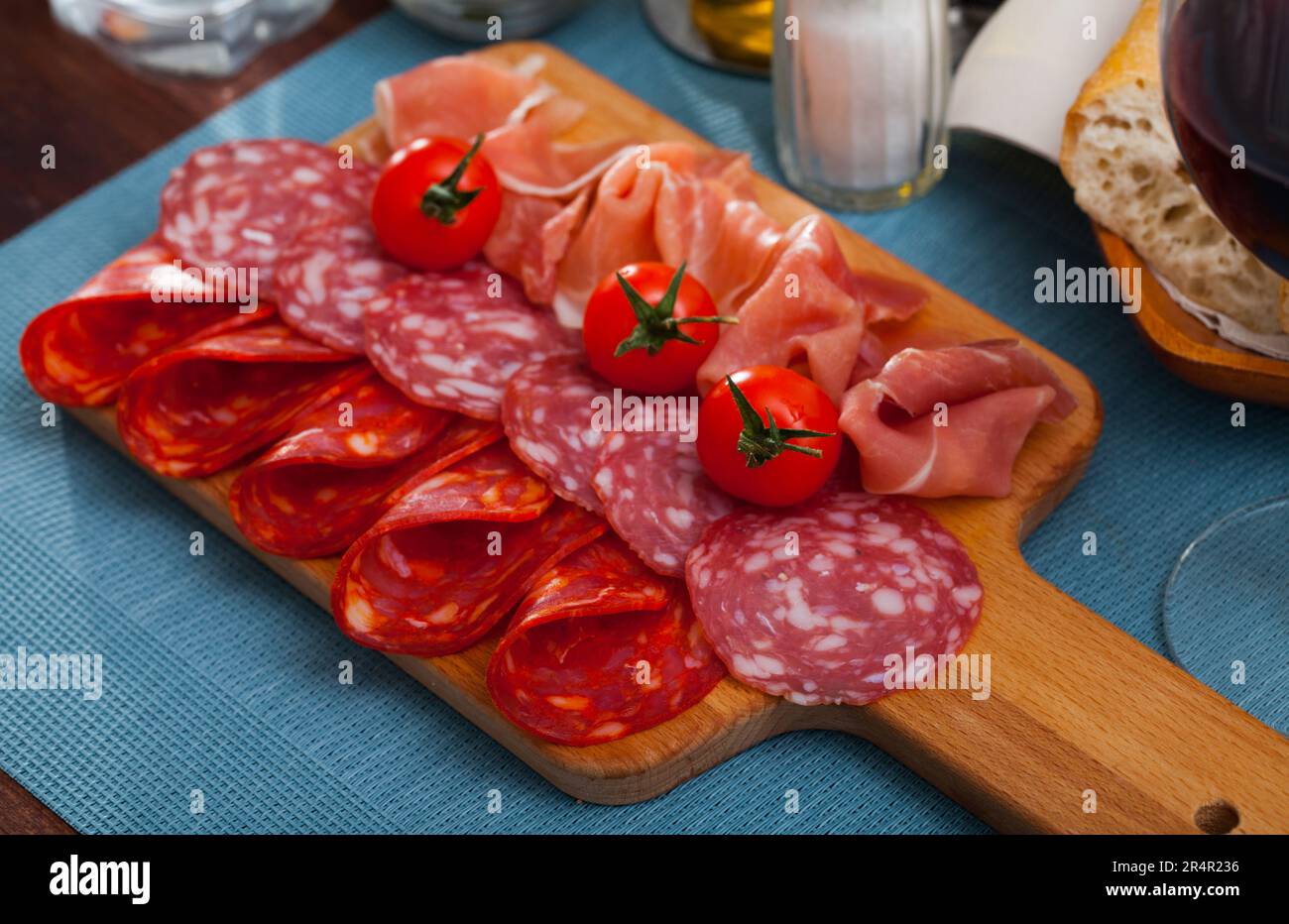 Spanische leckere Mahlzeit Würste und Jamon mit Tomaten schneiden, Nahaufnahme Stockfoto