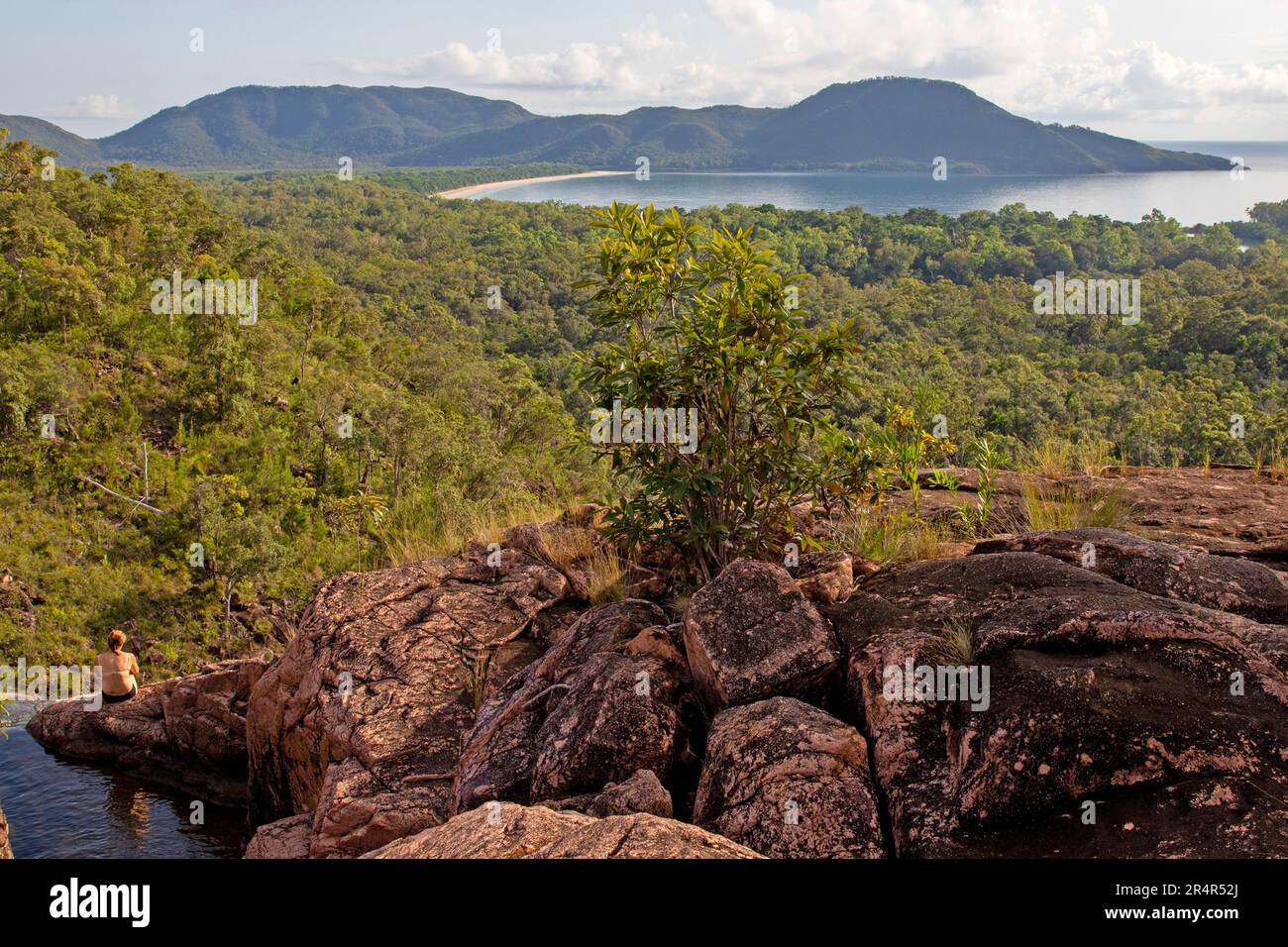 Eine Frau, die Zoe Bay von der Spitze der Zoe Falls, Hinchinbrook Island, überblickt Stockfoto