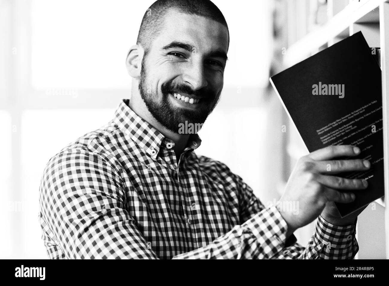 Stattliche männliche Kursteilnehmer mit Büchern Arbeiten in einer High School Bibliothek Stockfoto