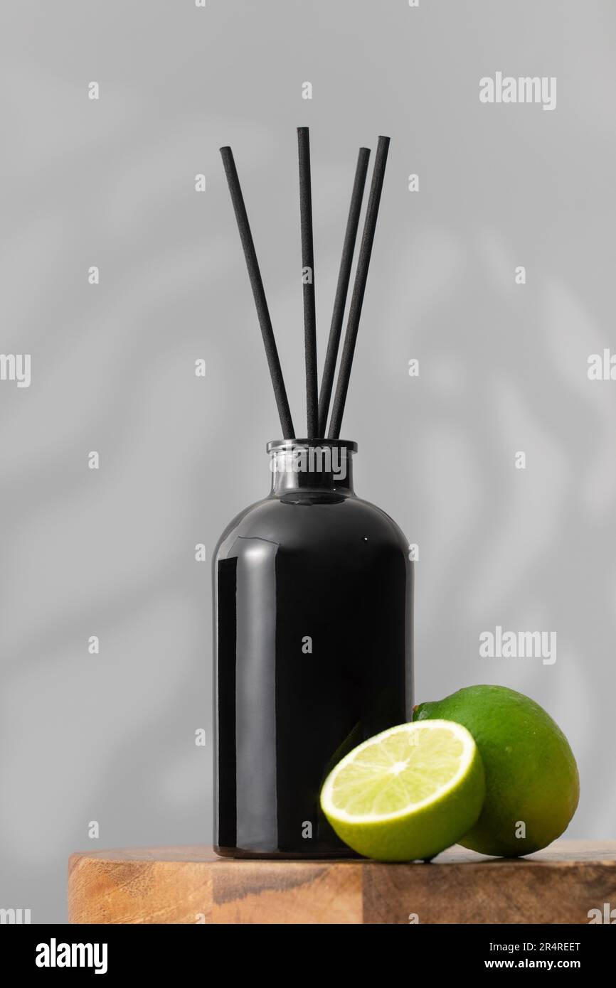 Bambusstäbchen in einer schwarzen Flasche mit nach Limette duftendem  Raumparfüm. Diffusor mit Duft für Zuhause Stockfotografie - Alamy