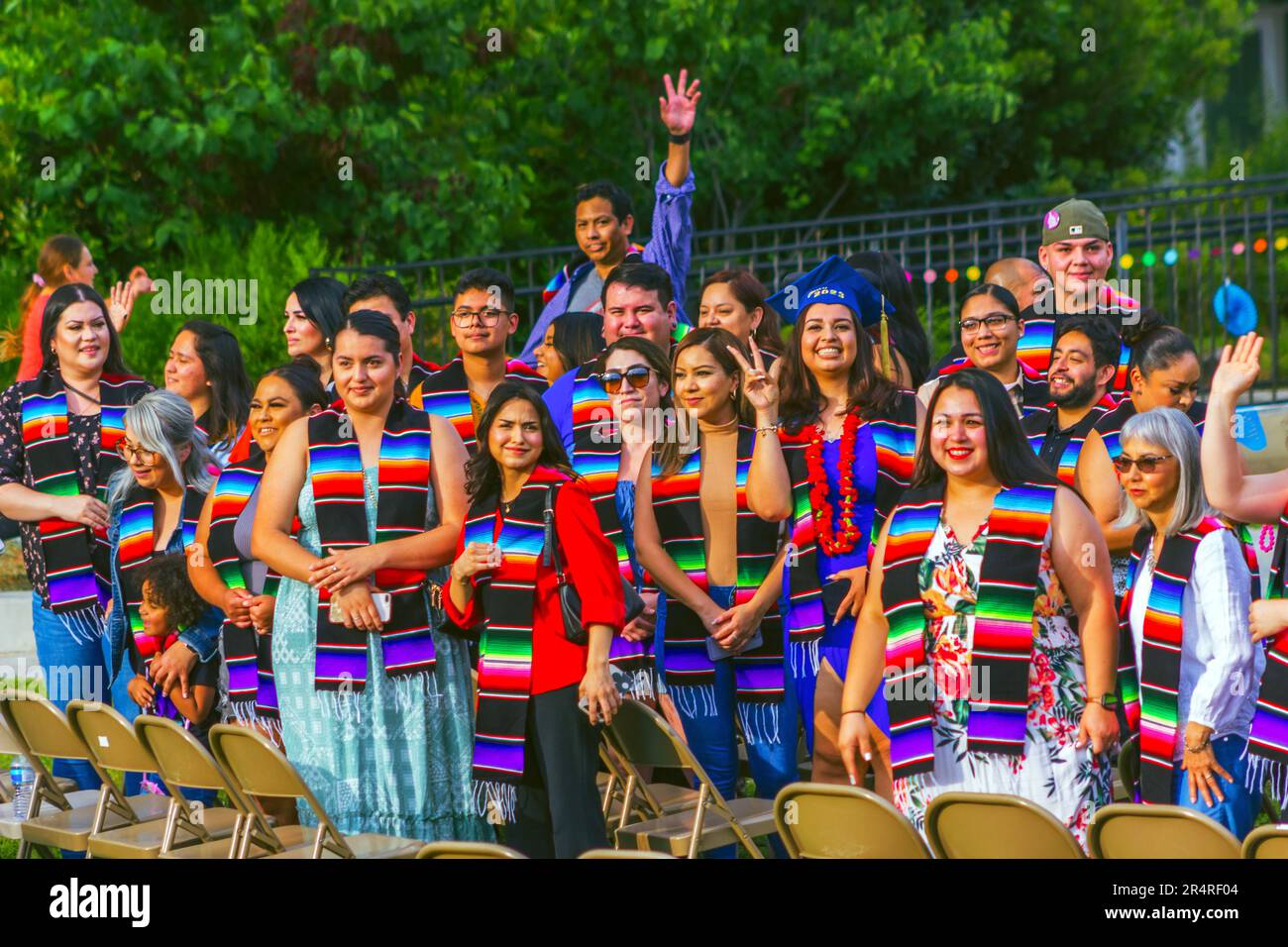 Ein fröhlicher Moment wird festgehalten, wenn Gio Skelton der Menge zuwinkt, nachdem er seinen Sarape Sash beim Crafton Hills College 2023 Nuestra Graduation empfangen hat Stockfoto