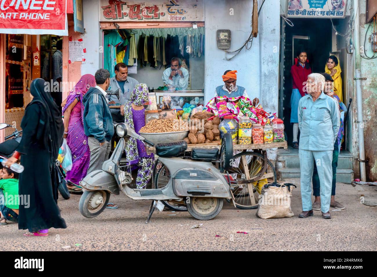 Mandawa, Rajasthan, Indien - 17. November 2015. Das tägliche Leben der Menschen in einer Nachbarschaftsstraße mit einem Imbisskarren, Roller und einer Wäscherei eines Imbissverkäufers. Stockfoto
