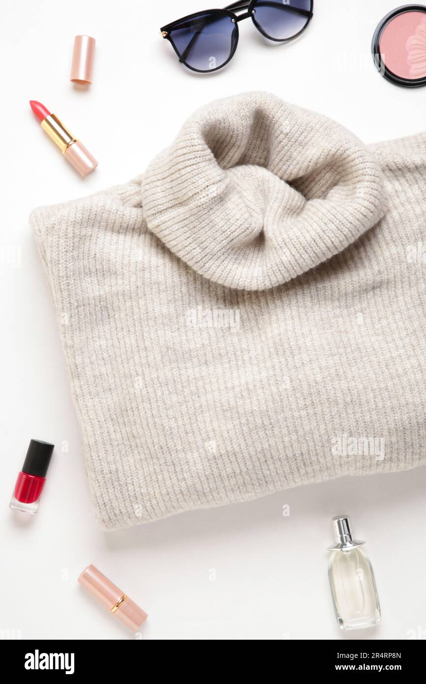 Damenmode und Accessoires. Flacher, lässiger weiblicher Look mit warmem Pullover und Sonnenbrille. Stockfoto