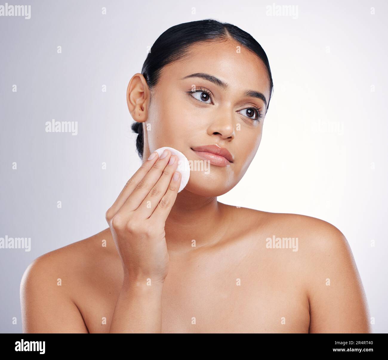 Gesicht, Reinigung und Baumwolle auf der Haut einer Frau im Studio für natürliche Schönheit, Dermatologie oder Kosmetik. Weibliche Person mit Hautpflegetüchern in der Hand für Glühen Stockfoto