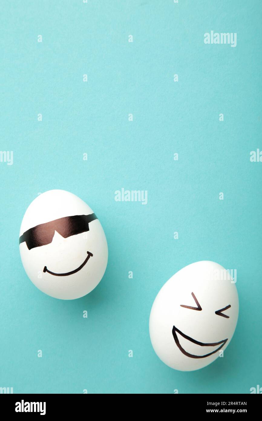 Lustige Ostereier mit verschiedenen Emotionen im Gesicht auf blauem Hintergrund. Osterkomposition. Draufsicht Stockfoto