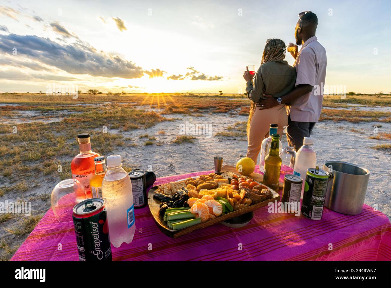 Paare, die sich im Onguma Game Reserve, Namibia, Afrika, bei Sonnenuntergang entspannen möchten Stockfoto