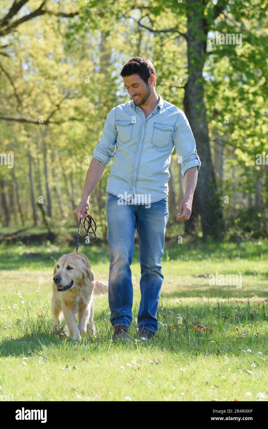 Der Mann geht mit seinem Hund Gassi Stockfoto