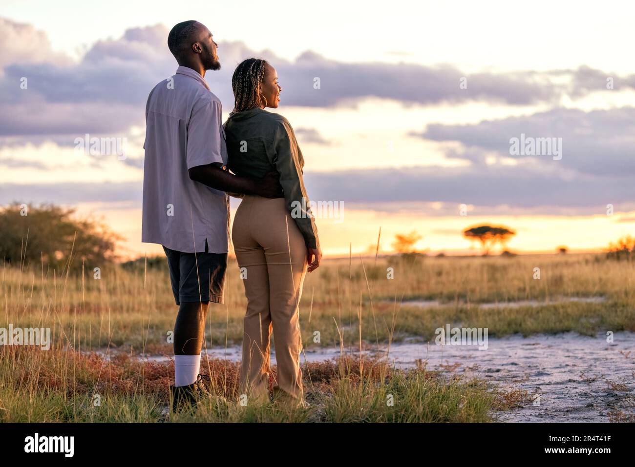 Ein Paar genießt den Sonnenuntergang im Onguma Game Reserve, Namibia, Afrika Stockfoto