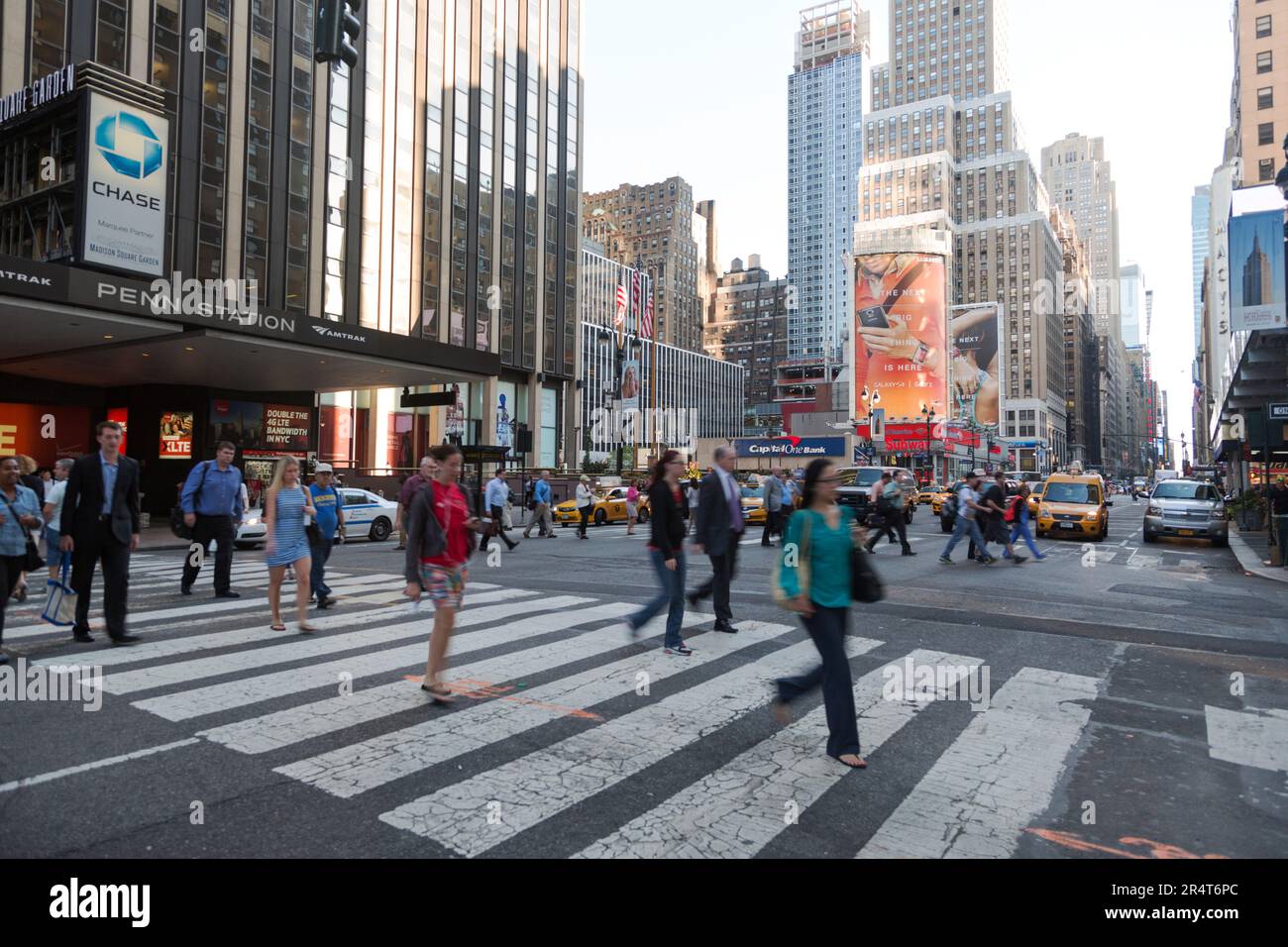 US, New York, Times Square, Fußgängerüberquerung in der Dämmerung auf der 7. Avenue außerhalb der Penn Station. Stockfoto