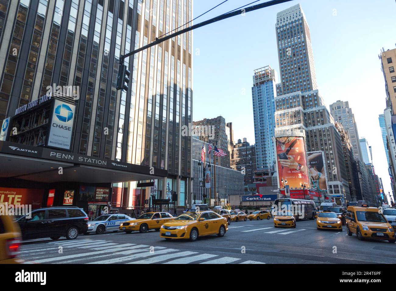 US, New York, Times Square, Fußgängerüberquerung in der Dämmerung auf der 7. Avenue außerhalb der Penn Station. Stockfoto