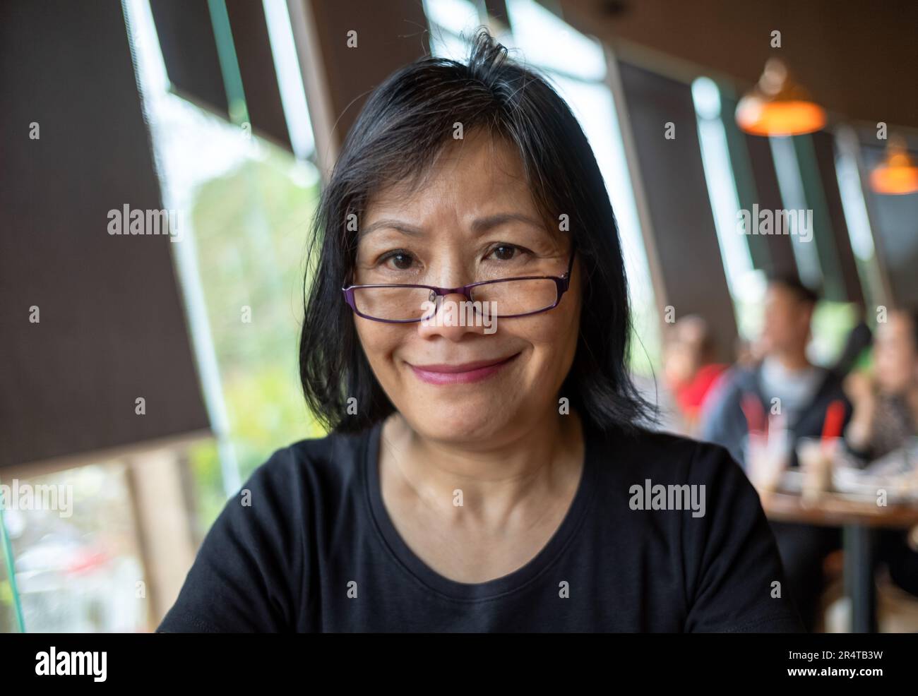 Eine vietnamesische Frau mit Brille lächelt, während sie in die Kamera schaut, Danang, Vietnam Stockfoto