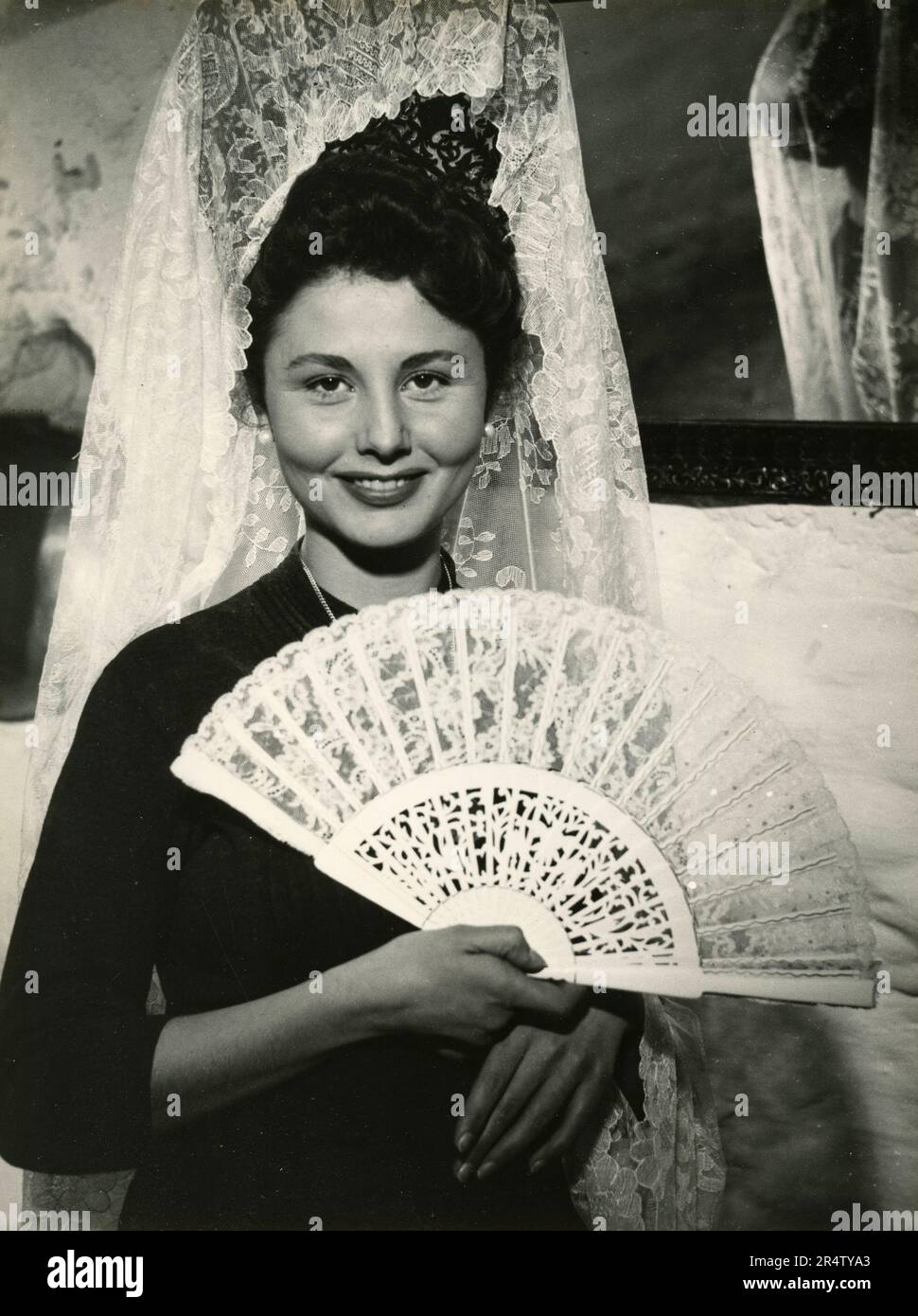 Junge Frau mit traditionellem Spitzenkopf, spanisches Kleid und Fächer, Spanien 1970er Stockfoto