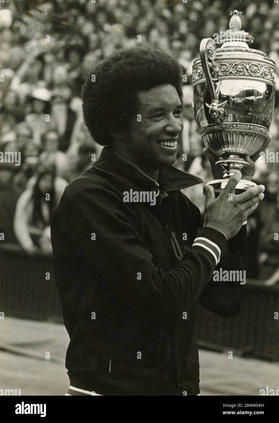 Der amerikanische Tennisspieler Arthur Ashe hat die Trophäe hochgehalten, nachdem er den Singles-Titel gewonnen hat, Wimbledon, UK 1975 Stockfoto