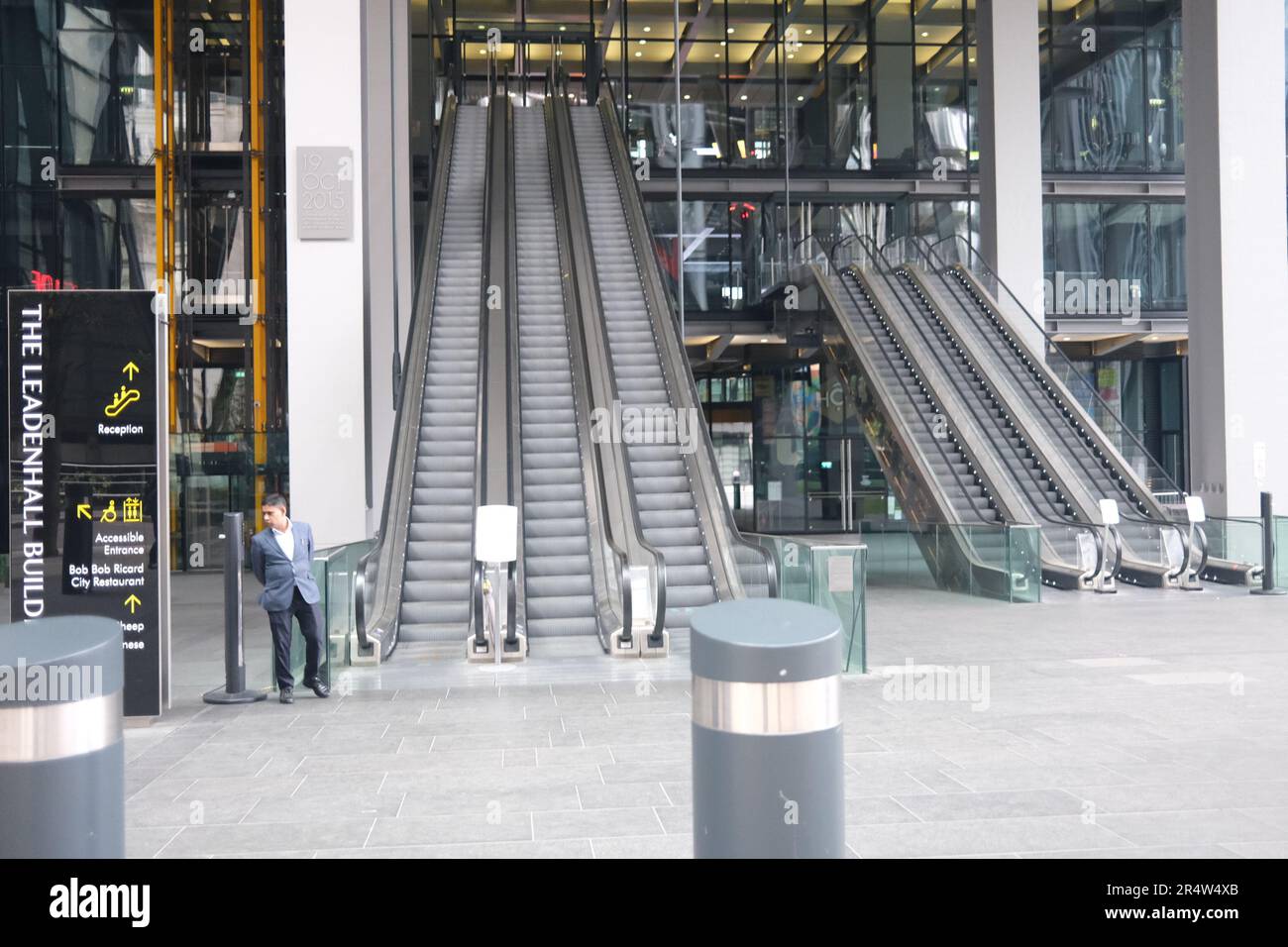 Ein eigenartig aussehender Mensch am Fuß der Rolltreppen vor dem Cheesegrater Building in der City of London Stockfoto