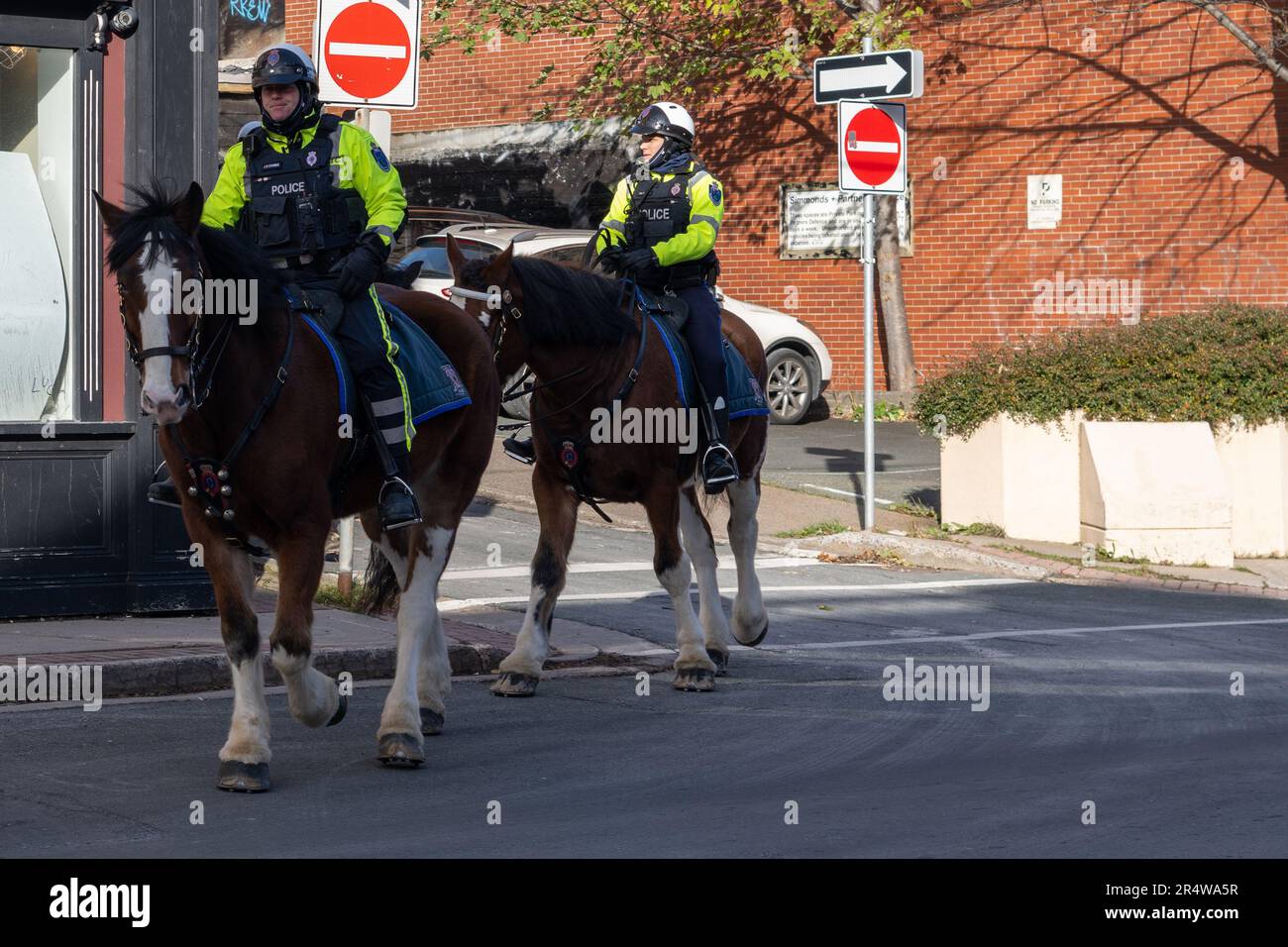 St. John's, Neufundland, Kanada-Mai 2023:Polizeibeamte der berittenen Einheit reiten große Pferde auf einer Straße. Der Polizist der Royal Neufundland Constabulary Stockfoto